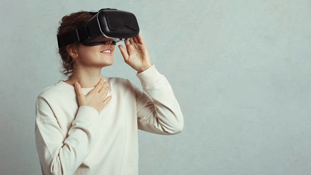 Vrouw met VR bril ervaart emotie. Hand tegen haar hals en glimlach.